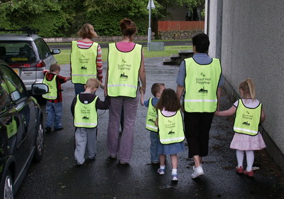 The children & their carers set out on a walk wearing their new safety vests